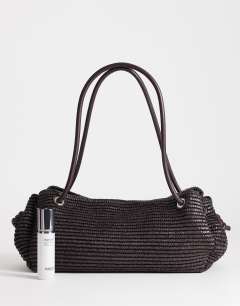 Model wearing Miller large straw shoulder bag in chocolate