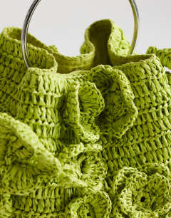 Model wearing Millie small straw flower grab bag with metal handle in lime