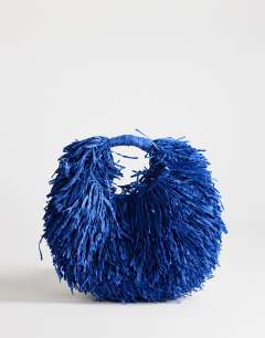 Model wearing Milo medium straw fringe grab bag in cobalt