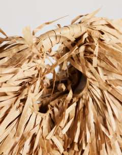 Model wearing Milo medium straw fringe grab bag in natural