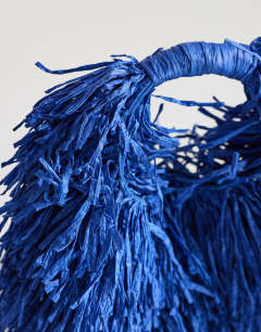 Model wearing Milo straw fringe grab bag in cobalt