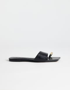 Model wearing Mina mule flat sandal with hardware in black