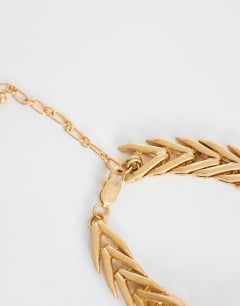 Model wearing Molly collar length arrow necklace in gold
