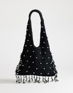 Model wearing Molly medium woven beaded bag in black