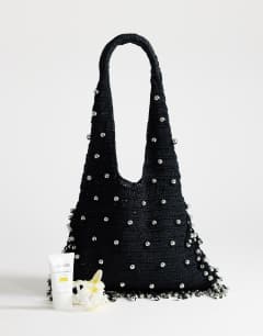 Model wearing Molly medium woven beaded bag in black