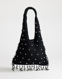Model wearing Molly medium woven beaded bag in black