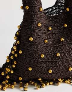 Model wearing Molly medium woven beaded bag in chocolate