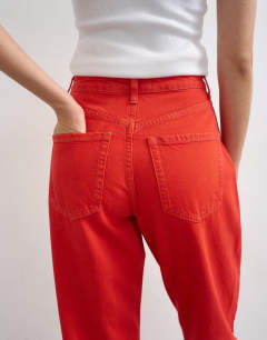 Model wearing Mom high rise loose fit jean in red