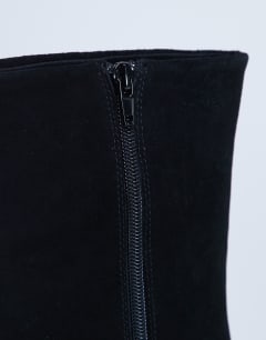 Model wearing Nadie chisel toe heeled ankle boot in black suede