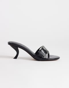 Model wearing Nadine mid heeled mule with buckle in black