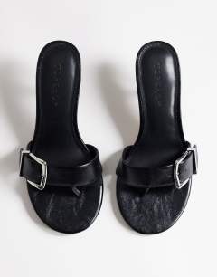 Model wearing Nadine mid heeled mule with buckle in black