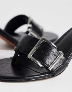 Model wearing Nadine mid heeled mule with buckle in black