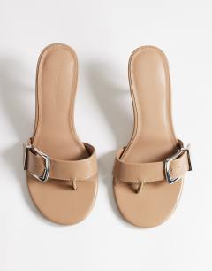 Model wearing Nadine mid heeled mule with buckle in taupe