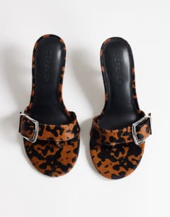 Model wearing Nadine real hair on leather mid heeled mule with buckle in leopard print