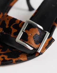 Model wearing Nadine real hair on leather mid heeled mule with buckle in leopard print