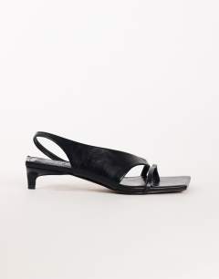 Model wearing Nadir asymmetric mid heel sandal in black