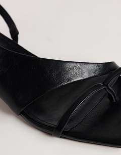 Model wearing Nadir asymmetric mid heel sandal in black