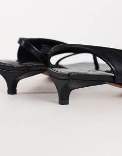 Model wearing Nadir asymmetric mid heel sandal in black