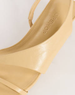Model wearing Nadir asymmetric mid heel sandal in mink