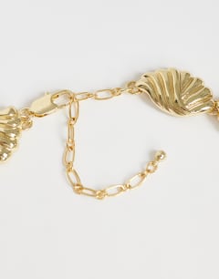 Model wearing Naleigh swirl necklace in gold