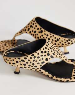 Model wearing Nancy toe thong mid heel sandal in caramel dalmatian print hair on real leather 