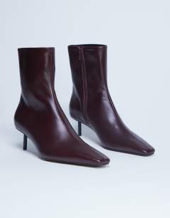 Model wearing Narla premium real leather high pin heeled ankle boots in burgundy
