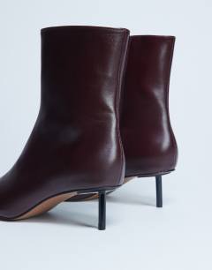 Model wearing Narla premium real leather high pin heeled ankle boots in burgundy
