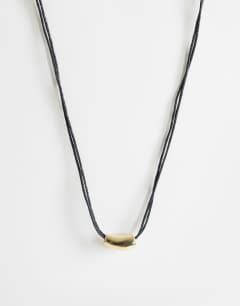 Model wearing Nasha cord necklace in black with gold