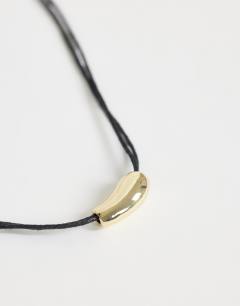 Model wearing Nasha cord necklace in black with gold