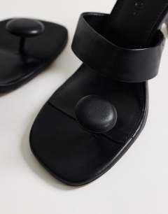 Model wearing Natalie toe thong angular mid heel sandal in black