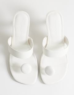 Model wearing Natalie toe thong angular mid heel sandal in white