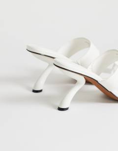 Model wearing Natalie toe thong angular mid heel sandal in white