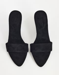 Model wearing Nathan cone heel mule in black faux suede
