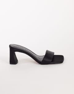 Model wearing Nela mid heel mule in black