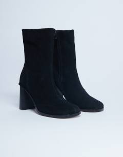 Model wearing Nellie suede heeled ankle boot black