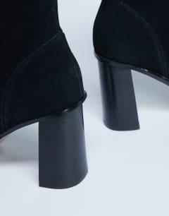Model wearing Nellie suede heeled ankle boot black