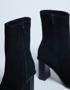 Model wearing Nellie suede heeled ankle boot black