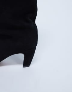 Model wearing Nelly real suede pointed toe slouch boot in black