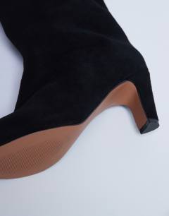 Model wearing Nelly real suede pointed toe slouch boot in black