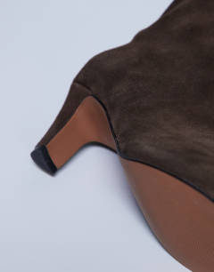 Model wearing Nelly real suede pointed toe slouch boot in chocolate