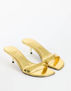 Model wearing Neptune kitten heel mule in gold
