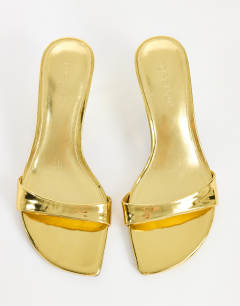Model wearing Neptune kitten heel mule in gold