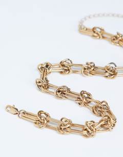 Model wearing Nicky waterproof stainless steal knot detailed necklace in gold