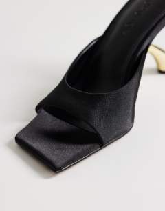 Model wearing Nicole angular mid heel mule in black satin