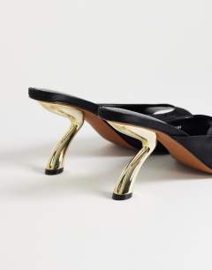 Model wearing Nicole angular mid heel mule in black satin