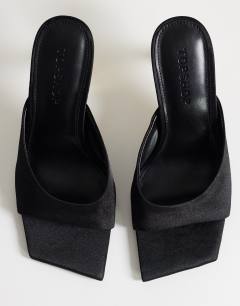 Model wearing Nicole angular mid heel mule in black satin