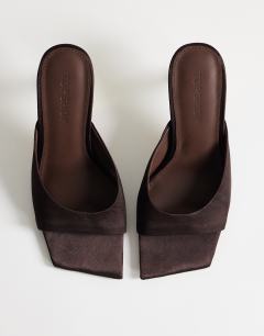 Model wearing Nicole angular mid heel mule in chocolate satin