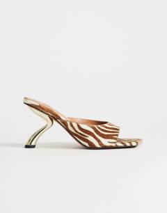 Model wearing Nicole angular mid heel mule in zebra print hair on real leather