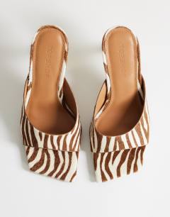 Model wearing Nicole angular mid heel mule in zebra print hair on real leather