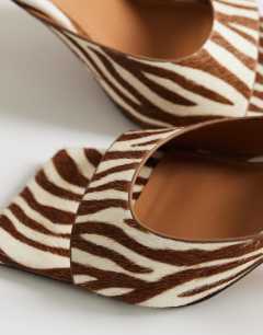Model wearing Nicole angular mid heel mule in zebra print hair on real leather